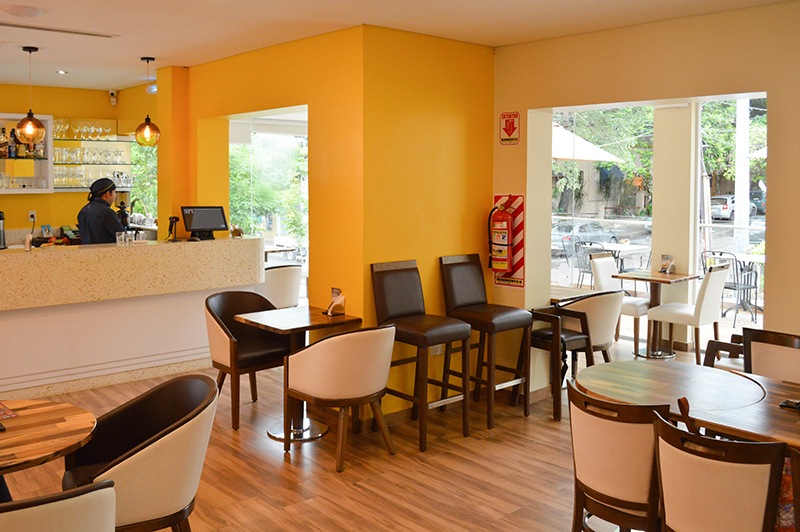 La cafetería en el interior salón, conectado al sector que da sobre la calle cerrada con vidrios y la terraza que da sobre la calle.