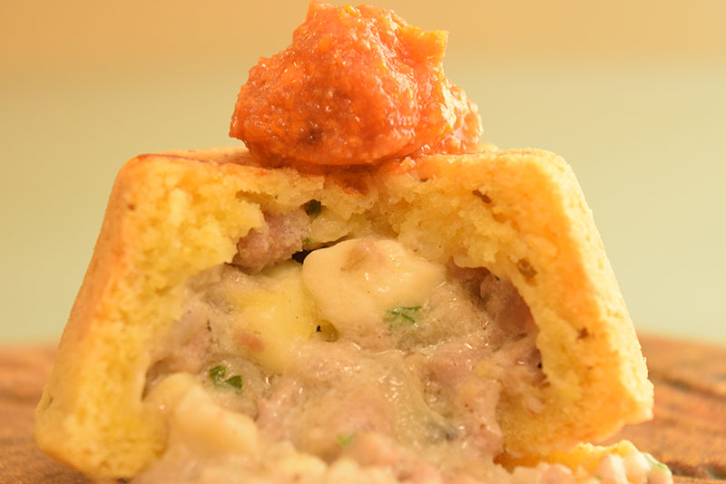 Primer plano de la chipa Chutita que lleva un relleno de carne y queso y se presenta en forma de volcán.