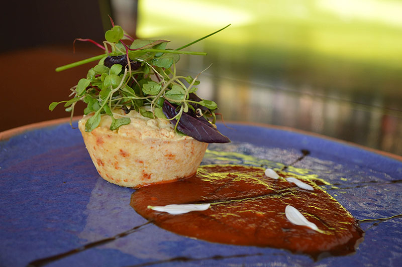 Mbeju avevo relleno con queso Camembert y muzarella. Mermelada de locotes rojos, toque de picante y ensalada de brotes vegetales. Sobre un colorido plato de Mango Rojo.