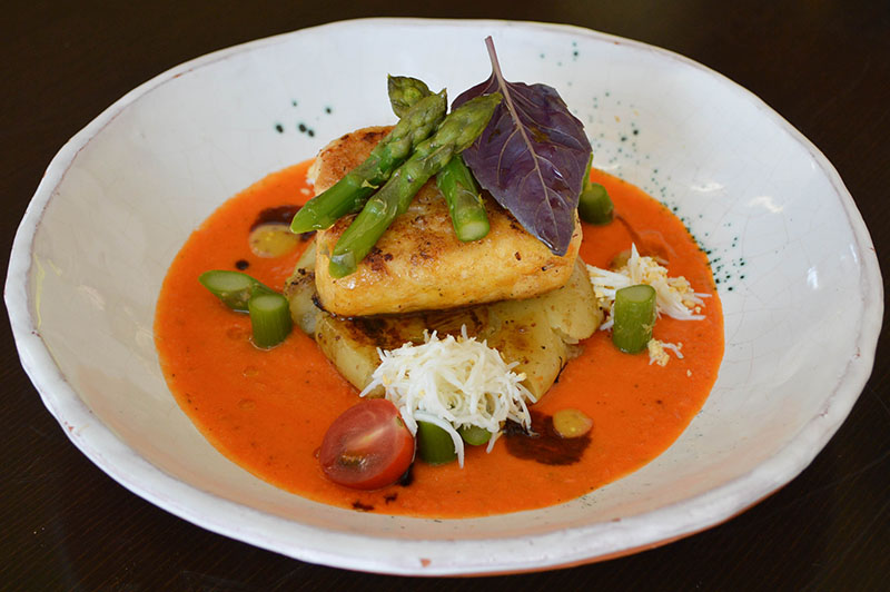 Surubi grillé con papas rotas y espárragos, sobre un salmorejo tibio para evitar mucho contraste de temperaturas y toque de huevo rallado.
