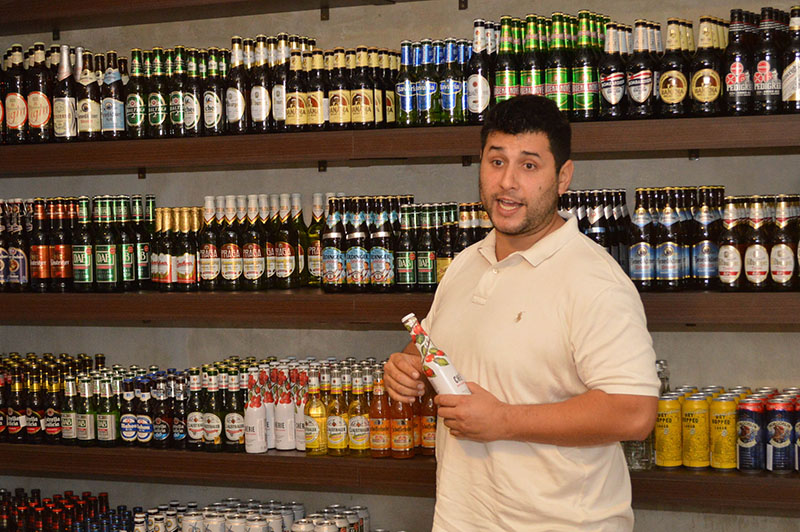 Jaime Peña González mostrando algunas de las tantas variedades de cervezas importadas que tienen a la venta.