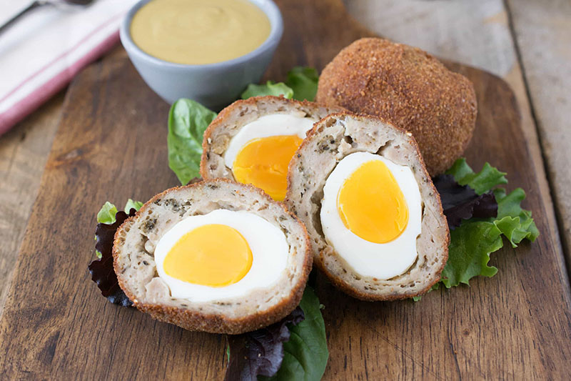 El huevo a la escocesa, una especie de villarroy que en vez de la salsa bechamel que rodea al huevo lleva carne de salchichas picadas. Fotografías de: culinaryginger.com