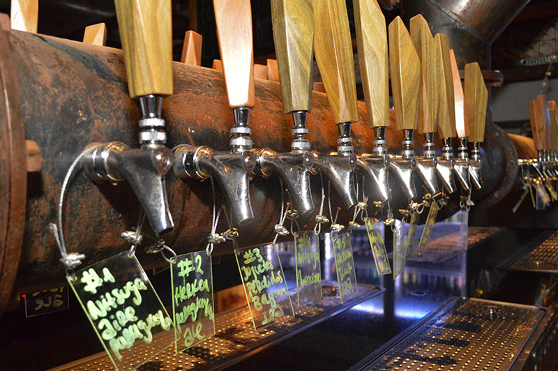 Cuarenta canillas tiene Palo Santo. Solo están habilitadas 28 y de ellas 6 con cervezas de la casa. Llegan hasta la barra ubicada en el centro del bar a través de un sistema de tuberías que transporta la cerveza ubicada en la cámara fría que está a unos 15 metros.