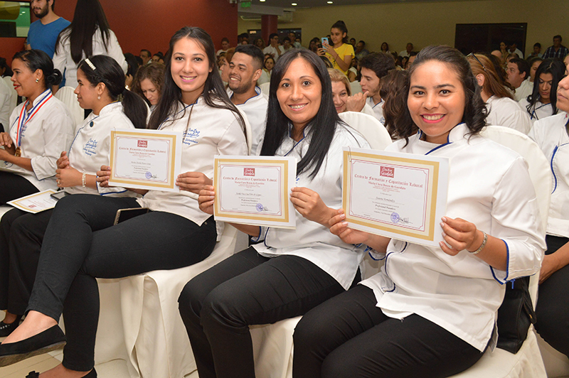 Egresadas del primer año muestran los certificados que los acreditan como Asistentes de Gastronomía, durante uno de los actos de colación en el Centro Garofalo.