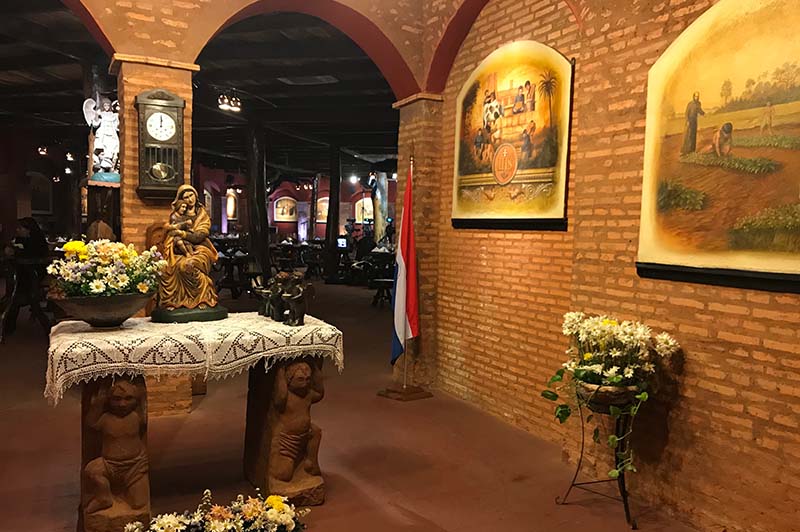 La entrada al museo Mbororé. Imágenes con motivos religiosos, casi como un templo. Más allá el salón donde se lucen las pizzas.