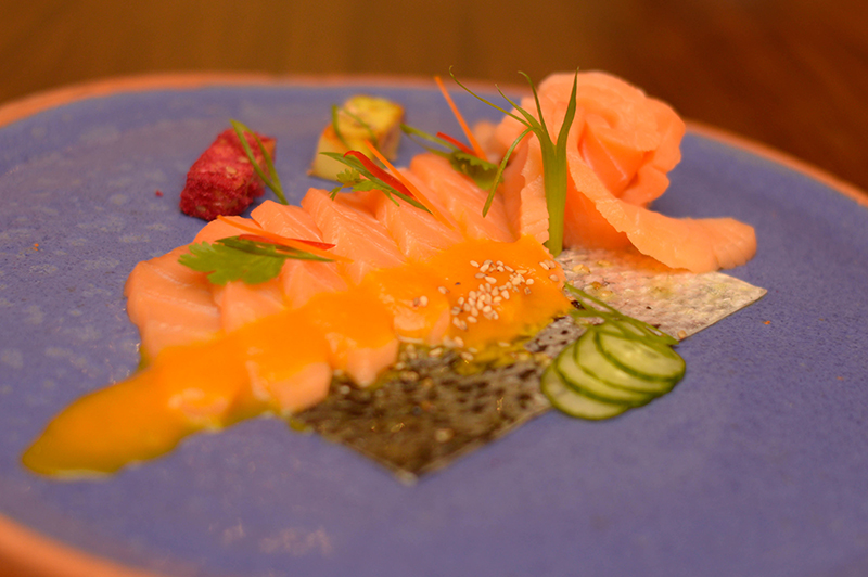 Una de las entradas frías sera el tiradito de salmón en salsa de ají amarillo con un poco de palta a la parrilla, algo nuevo que se está y cae bastante bien al plato.