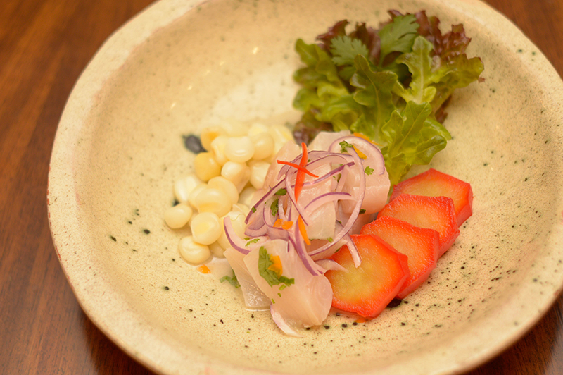 El ceviche de pescado acaompañado de choclos peruanos al anis y camote glaseado con jugo de naranja.