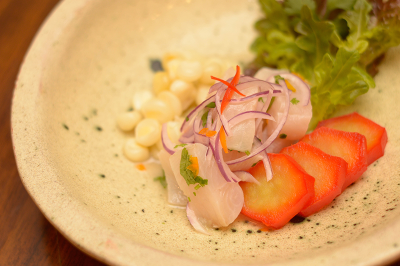 El ceviche de pescado acaompañado de choclos peruanos al anis y camote glaseado con jugo de naranja.