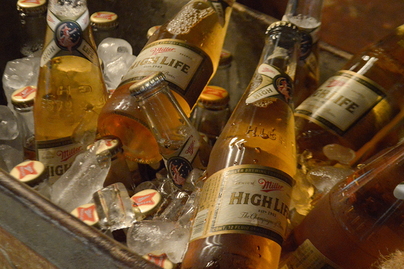 La Miller High Life lleva en su etiqueta la inscripción The Champagne of Beers. En la parte superior de la botella se observa la icónica imagen Girl in the moon.