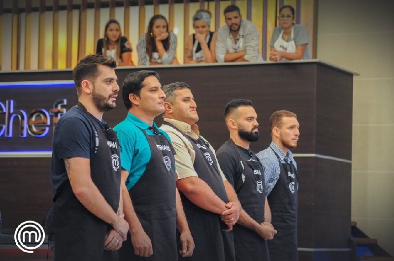 Armando, primero de la izquierda, se eliminó anoche. Todos varones en la tanda de eliminación. Las mujeres mirando desde el balcón junto a Joaquín quien hizo el mejor postre. Foto del sitio oficial de MasterChef Paraguay
