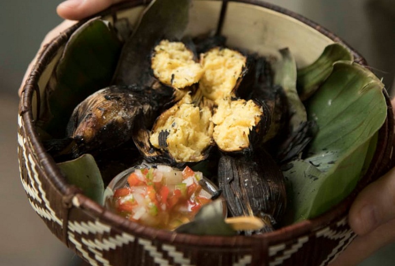 Kai kua, elaborada con una masa parecida a la de la chipa guazú, se rellena la chala, se cocina al vapor y se termina al tatakua. Se acompaña con una salsa criolla con umeboshi (una variedad de ciruela).
