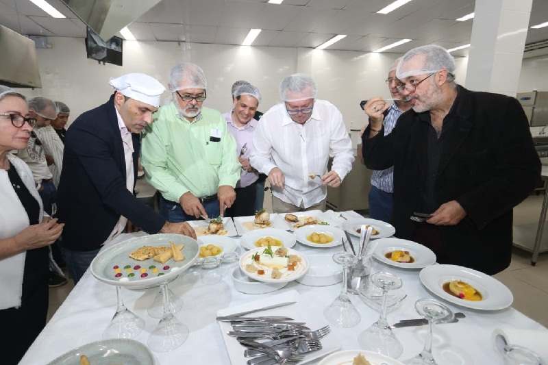 Miembros del jurado probando y degustando los platos presentados.