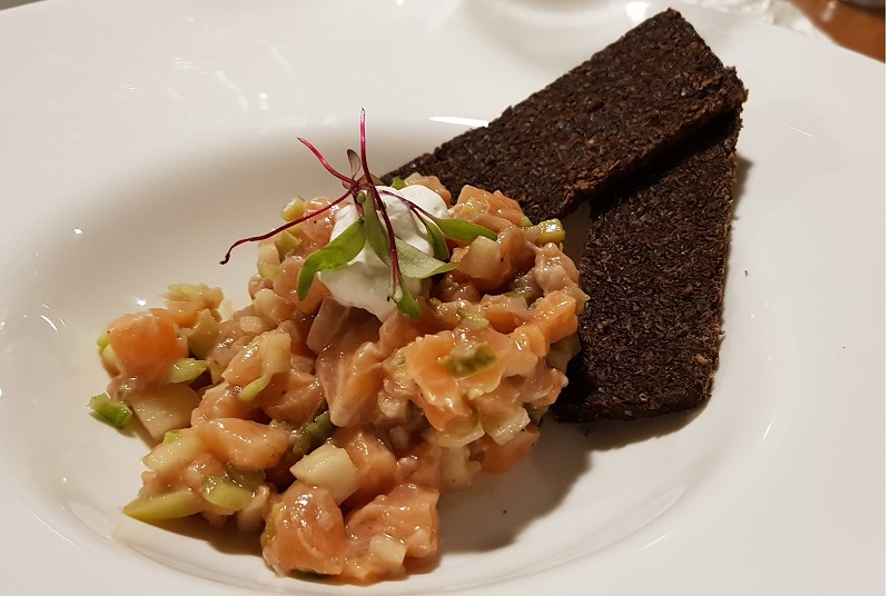 Tartar de salmón con manzana encurtidas y crocante de pan Pernikel.