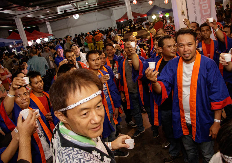 Un brindis con sake previo a la procesión con el Mikoshi, la capilla portátil del sintoísmo, que estos hombres portaron al hombro como parte de la celebración del Nihon Matsuri.