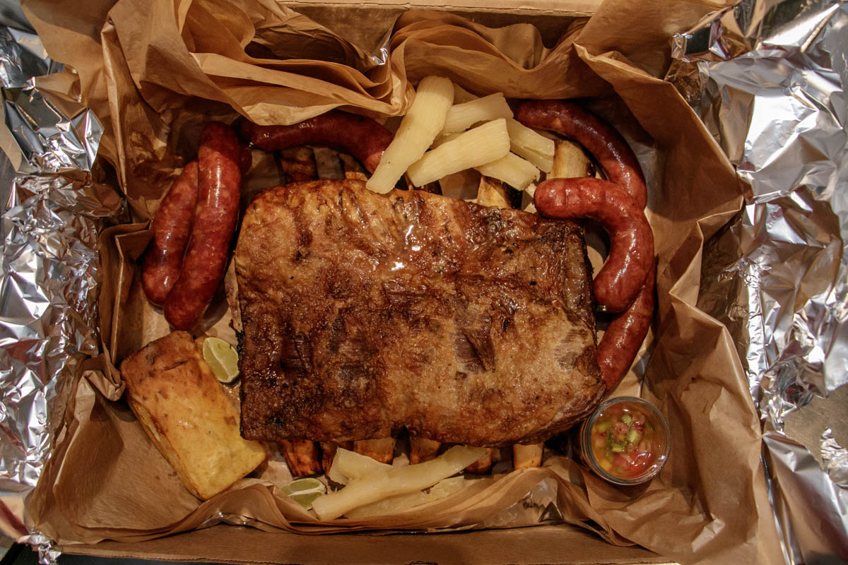 La Caja de Pozo. Alli se incluuyen, 5 kilos de asado, 1 pollo entero, 1 kilo de chorizos artesanales, chipa guazu, sopa paraguaya, ensalada verde y mandioca.
